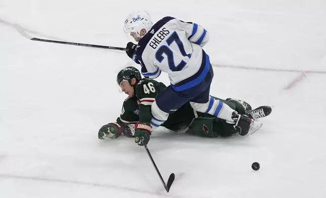 Minnesota Wild defenseman Jared Spurgeon (46) and Winnipeg Jets left wing Nikolaj Ehlers (27) collide during the second period of an NHL hockey game, Monday, Nov. 25, 2024, in St. Paul, Minn. (AP Photo/Abbie Parr)