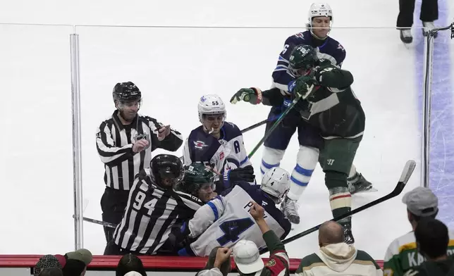 Minnesota Wild and Winnipeg Jets players fight during the second period of an NHL hockey game, Monday, Nov. 25, 2024, in St. Paul, Minn. (AP Photo/Abbie Parr)