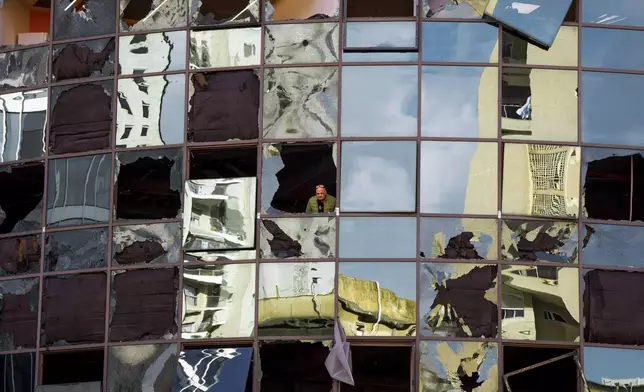 A man looks from a damaged building a day after it was hit by a rocket fired from Lebanon, in Ramat Gan, central Israel, Tuesday, Nov. 19, 2024. (AP Photo/Oded Balilty)