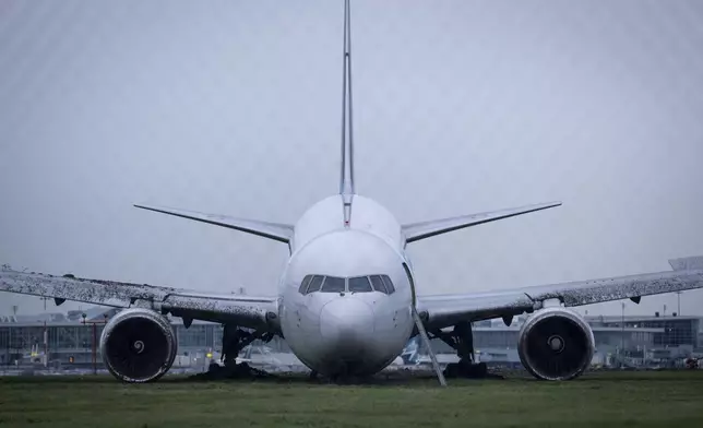 An Amazon Prime Air Boeing 767-338 sits on the grass after overrunning the runway, at the Vancouver International Airport in Richmond, British Columbia, Tuesday, Nov. 19, 2024. (Ethan Cairns/The Canadian Press via AP)