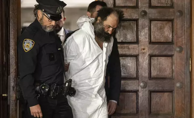 Ramon Rivera, a suspect arrested after multiple people were stabbed early Monday, is escorted out by NYPD officers at the NYPD 10th Precinct in New York, Monday, Nov. 18, 2024. (AP Photo/Yuki Iwamura)