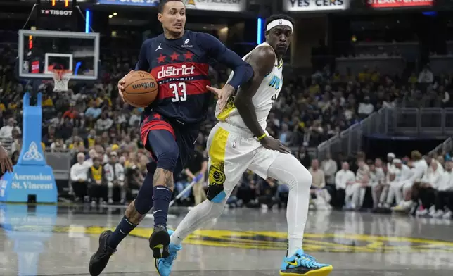 Washington Wizards' Kyle Kuzma (33) goes to the basket against Indiana Pacers' Pascal Siakam, right, during the first half of an NBA basketball game, Sunday, Nov. 24, 2024, in Indianapolis. (AP Photo/Darron Cummings)