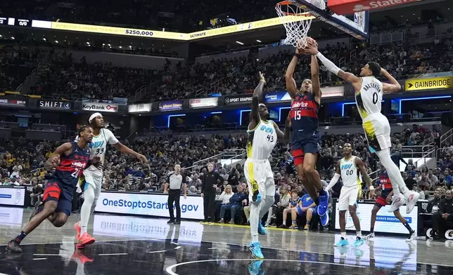 Washington Wizards' Malcolm Brogdon (15) shoots against Indiana Pacers' Pascal Siakam (43) and Tyrese Haliburton (0) during the first half of an NBA basketball game, Sunday, Nov. 24, 2024, in Indianapolis. (AP Photo/Darron Cummings)