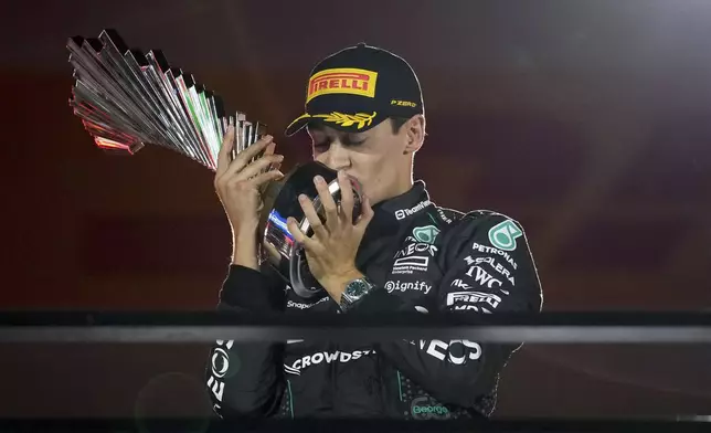 Mercedes driver George Russell, of Britain, celebrates on the podium after winning during the F1 Las Vegas Grand Prix auto race, Saturday, Nov. 23, 2024, in Las Vegas. (AP Photo/John Locher)