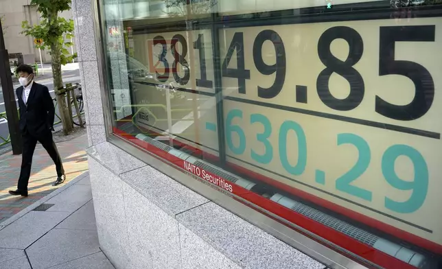 A person walks in front of an electronic stock board showing Japan's Nikkei index at a securities firm Tuesday, Nov. 26, 2024, in Tokyo. (AP Photo/Eugene Hoshiko)