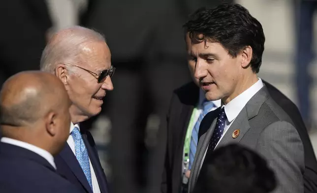 U.S. President Joe Biden, left, and Canada's Prime Minister Justin Trudeau, arrive late for a group photo during the G20 Summit in Rio de Janeiro, Monday, Nov. 18, 2024. (AP Photo/Eraldo Peres)