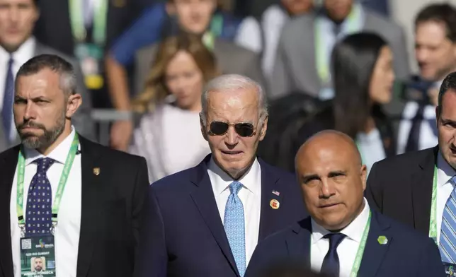 U.S. President Joe Biden arrives late for the group photo during the G20 Summit in Rio de Janeiro, Monday, Nov. 18, 2024. (AP Photo/Eraldo Peres)