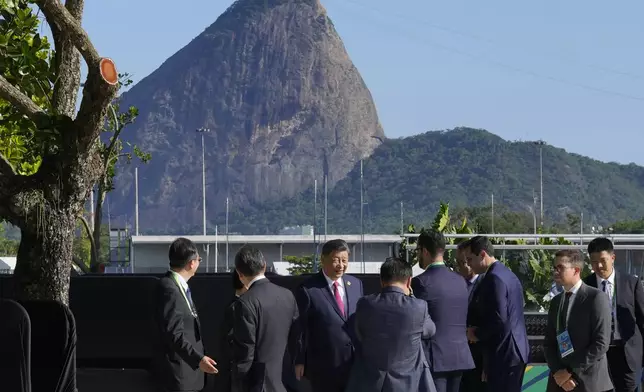 Backdropped by Sugar Loaf mountain, China's President Xi Jinping, center, walks after joining a group photo during the G20 Summit in Rio de Janeiro, Monday, Nov. 18, 2024. (AP Photo/Eraldo Peres)