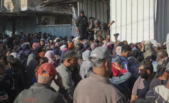 Residents gather in front of a bakery to get their share of bread in Deir al-Balah, Gaza Strip, Thursday, Nov. 21, 2024. (AP Photo/Abdel Kareem Hana)