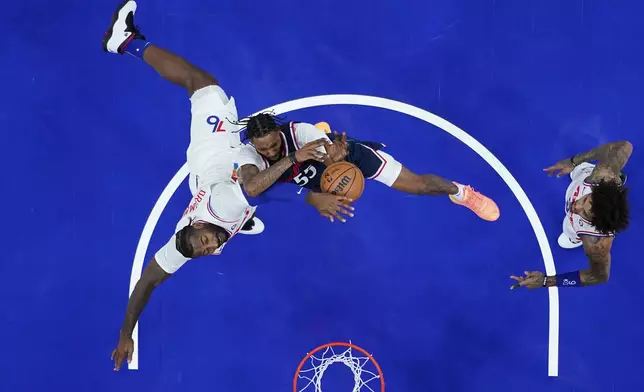 Los Angeles Clippers' Derrick Jones Jr., center, cannot get a shot past Philadelphia 76ers' Andre Drummond, left, during the first half of an NBA basketball game, Sunday, Nov. 24, 2024, in Philadelphia. (AP Photo/Matt Slocum)