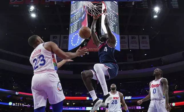 Los Angeles Clippers' Mo Bamba (4) dunks the ball as Philadelphia 76ers' Eric Gordon (23), Guerschon Yabusele (28) and Tyrese Maxey (0) look on during the first half of an NBA basketball game, Sunday, Nov. 24, 2024, in Philadelphia. (AP Photo/Matt Slocum)