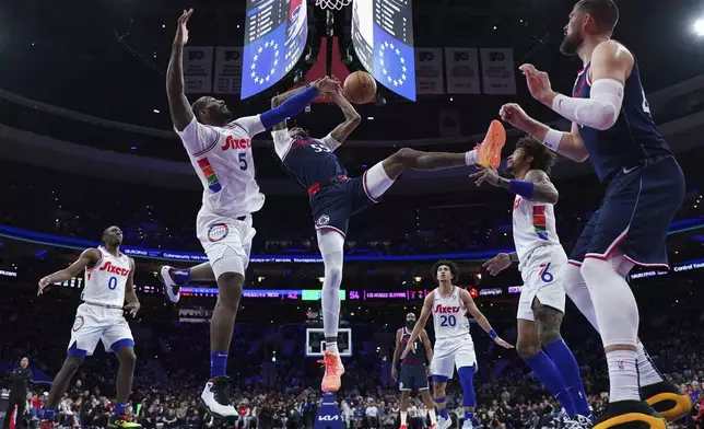 Los Angeles Clippers' Derrick Jones Jr. (55) cannot get a shot past Philadelphia 76ers' Andre Drummond (5) during the first half of an NBA basketball game, Sunday, Nov. 24, 2024, in Philadelphia. (AP Photo/Matt Slocum)