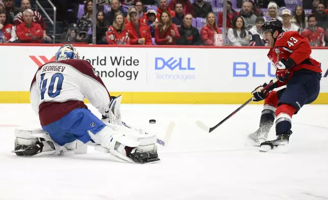 Colorado Avalanche goalie Alexandar Georgiev (40) deflects the puck against Washington Capitals right wing Tom Wilson (43) during the first period of an NHL hockey game, Thursday, Nov. 21, 2024, in Washington. (AP Photo/Nick Wass)