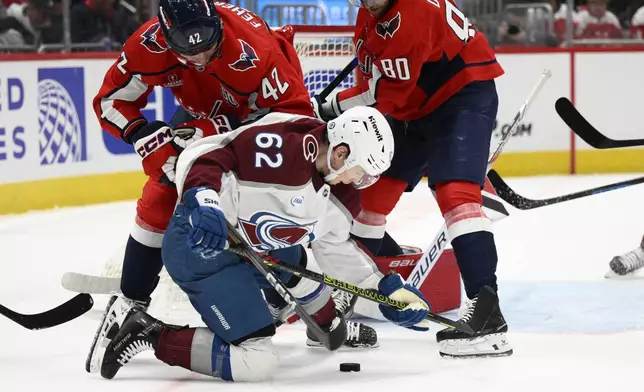 Washington Capitals defenseman Martin Fehervary (42) and left wing Pierre-Luc Dubois (80) and Colorado Avalanche left wing Artturi Lehkonen (62) battle for the puck during the second period of an NHL hockey game, Thursday, Nov. 21, 2024, in Washington. (AP Photo/Nick Wass)