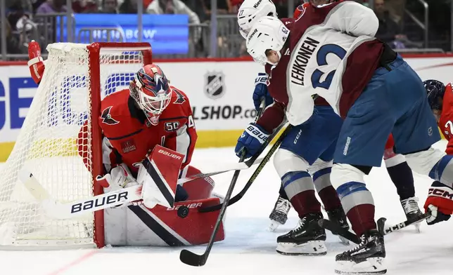 Colorado Avalanche left wing Artturi Lehkonen (62) and left wing Jonathan Drouin, center, try to get the puck past Washington Capitals goaltender Logan Thompson,left, during the second period of an NHL hockey game, Thursday, Nov. 21, 2024, in Washington. (AP Photo/Nick Wass)