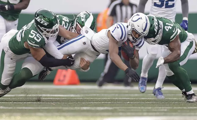 Indianapolis Colts wide receiver Josh Downs (1) is tackled by New York Jets linebacker Chazz Surratt (55), long snapper Thomas Hennessy (42) and linebacker Marcelino McCrary-Ball (41) during the second quarter of an NFL football game, Sunday, Nov. 17, 2024, in East Rutherford, N.J. (AP Photo/Adam Hunger)