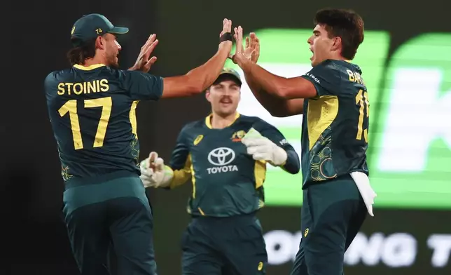 Australia's Xavier Bartlett, right, is congratulated by teammate Marcus Stoinis, left, after dismissing Pakistan's Mohammad Rizwan during the T20 cricket international between Pakistan and Australia at the Gabba in Brisbane, Australia, Thursday, Nov. 14, 2024. (AP Photo/Tertius Pickard)