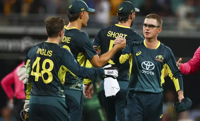 Australia's Adam Zampa, right, celebrates with teammates after defeating Pakistan during the T20 cricket international between Pakistan and Australia at the Gabba in Brisbane, Australia, Thursday, Nov. 14, 2024. (AP Photo/Tertius Pickard)