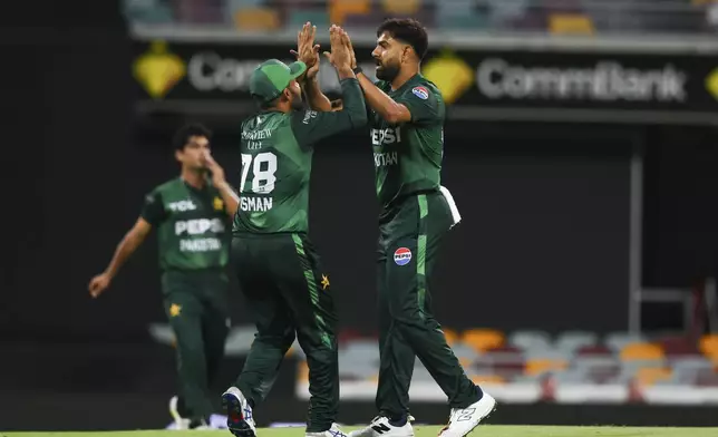 Pakistan's Haris Rauf and Usman Khan, left, celebrate the dismissal of Australia's Matt Short during the T20 cricket international between Pakistan and Australia at the Gabba in Brisbane, Australia, Thursday, Nov. 14, 2024. (AP Photo/Tertius Pickard)