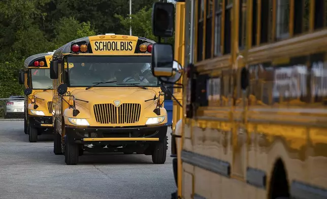 FILE - Jefferson County Public Schools buses make their way through the Detrick Bus Compound on the first day of school, Aug. 9, 2023, in Louisville, Ky. (Jeff Faughender/Courier Journal via AP, File)