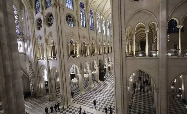 People stroll in Notre-Dame de Paris cathedral while French President Emmanuel Macron visits the restored interiors the monument, Friday, Nov.29, 2024 in Paris. (Christophe Petit Tesson, Pool via AP)