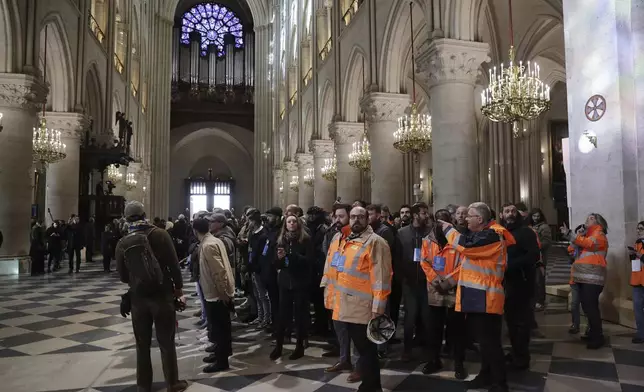 Construction workers who took part to the Notre-Dame cathedral restoration visit the cathedral after French President Emmanuel Macron's visit of the restored interiors, Friday, Nov.29, 2024 in Paris. (Christophe Petit Tesson, Pool via AP)