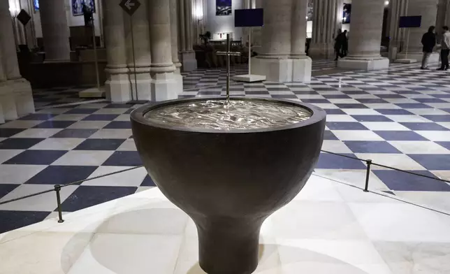 The baptistery designed by French artist and designer Guillaume Bardet is seen at Notre-Dame de Paris cathedral while French President Emmanuel Macron visits the restored interiors of the monument, Friday Nov. 29, 2024, in Paris. (Stephane de Sakutin, Pool via AP)