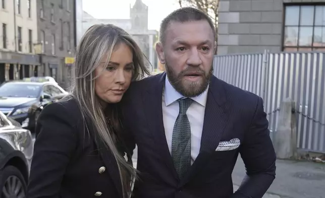 Mixed martial arts fighter Conor McGregor and partner Dee Devlin walk outside the High Court in Dublin, Ireland, where he is appearing for a personal injury case against him, on Friday Nov. 22, 2024. (Brian Lawless/PA via AP)