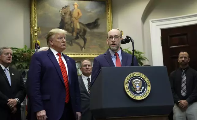 FILE - President Donald Trump, left, listens as acting director of the Office of Management and Budget Russel Vought speaks during an event on "transparency in Federal guidance and enforcement" in the Roosevelt Room of the White House, Oct. 9, 2019, in Washington. (AP Photo/Evan Vucci, File)