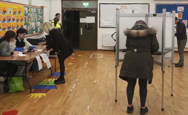 Voters cast their ballots at Delgany National School, County Wicklow, as voters go to the polls for the 2024 General Election in Ireland, Friday Nov. 29, 2024. (Niall Carson/PA via AP)