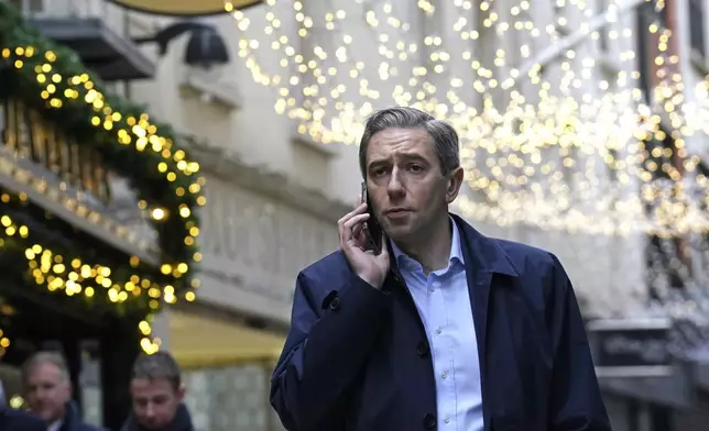 Irish Prime Minister and Fine Gael leader Simon Harris, center, speaks on the phone during a walkabout on the last day of campaigning, on the eve of the General Election, in Dublin, Thursday, Nov. 28, 2024. (Brian Lawless/PA via AP)