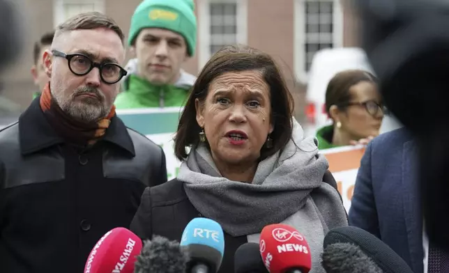 Sinn Fein leader Mary Lou McDonald, center, speaks to the media outside Government Buildings, on the last day of campaigning on the eve of the General Election, in Dublin, Thursday, Nov. 28, 2024. (Brian Lawless/PA via AP)