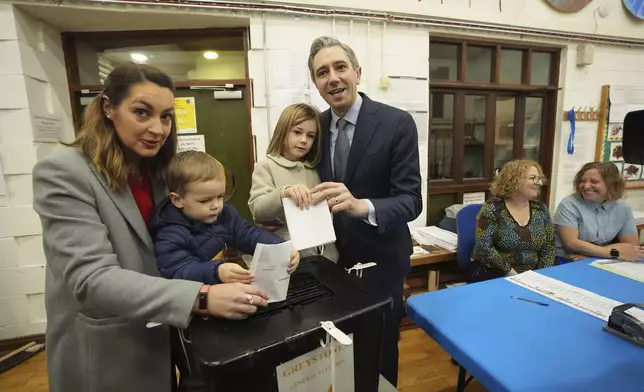 Irish Prime Minister and Fine Gael leader Simon Harris, center, accompanied by his wife Caoimhe and children Cillian and Saoirse, casts his vote at Delgany National School, County Wicklow, as voters go to the polls for the 2024 General Election in Ireland, Friday Nov. 29, 2024. (Niall Carson/PA via AP)