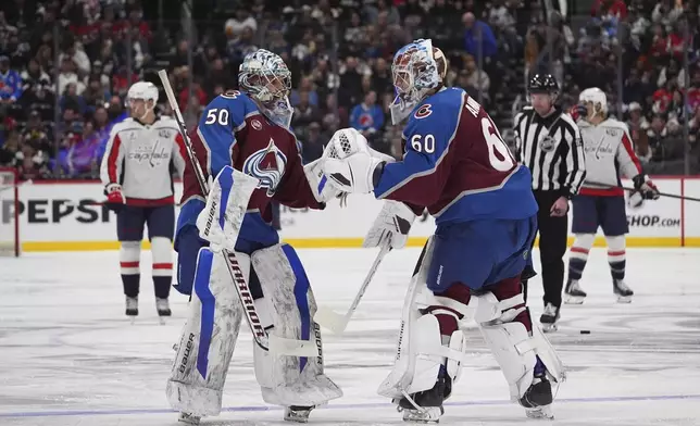 Colorado Avalanche goalie Trent Miner (50) comes in to replace goaltender Justus Annunen (60) after Annunen was pulled in the second period of an NHL hockey game against the Washington Capitals, Friday, Nov. 15, 2024, in Denver. (AP Photo/David Zalubowski)