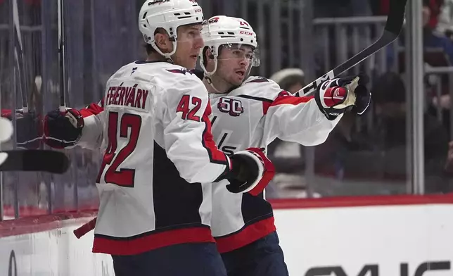 Washington Capitals defenseman Martin Fehervary, left, congratulates center Connor McMichael after McMichael scored against the Colorado Avalanche in the first period of an NHL hockey game Friday, Nov. 15, 2024, in Denver. (AP Photo/David Zalubowski)