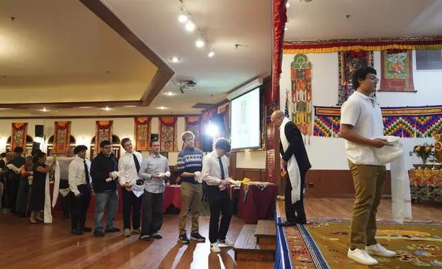 High school friends and fellow football players line up to present U.S.-born Buddhist lama, Jalue Dorje, with “khata,” the Tibetan ceremonial scarves that symbolize auspiciousness, at his 18th birthday and enthronement ceremony, in Isanti, Minn., on Saturday, Nov. 9, 2024. (AP Photo/Jessie Wardarski)