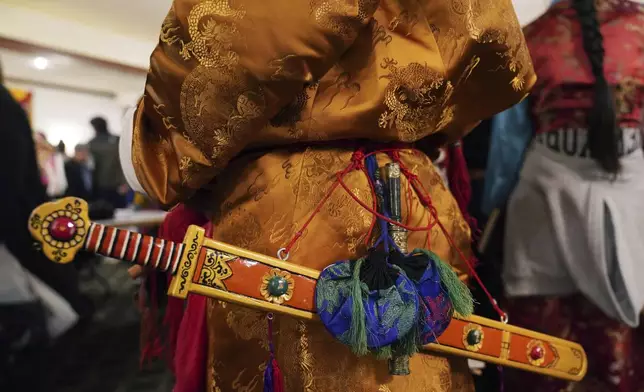 Elders dress in traditional clothing to perform a ceremonial Tibetan dance to welcome U.S.-born Buddhist lama, Jalue Dorje, to his 18th birthday and enthronement ceremony in Isanti, Minn., on Saturday, Nov. 9, 2024. (AP Photo/Jessie Wardarski)