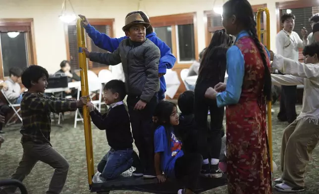 Kids play in a back room of the Tibetan American Foundation of Minnesota during the 18th birthday and enthronement ceremony for U.S.-born Buddhist lama, Jalue Dorje, in Isanti, Minn., on Saturday, Nov. 9, 2024. (AP Photo/Jessie Wardarski)