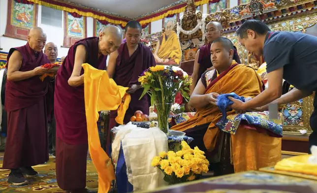 Monks bow and present “khata” to teenage Buddhist lama, Jalue Dorje, at his 18th birthday and enthronement ceremony in Isanti, Minn., on Saturday, Nov. 9, 2024. (AP Photo/Jessie Wardarski)