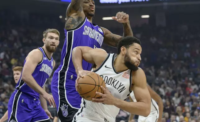 Brooklyn Nets guard Ben Simmons, right, is guarded by Sacramento Kings forward Domantas Sabonis, left, and DeMar DeRozan, center, during the first half of an NBA basketball game in Sacramento, Calif., Sunday, Nov. 24, 2024. (AP Photo/Randall Benton)