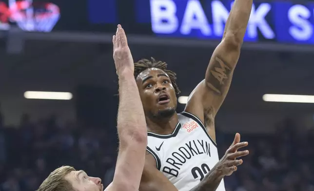 Brooklyn Nets center Nic Claxton, right, lays up the ball over Sacramento Kings forward Domantas Sabonis, left, during the first half of an NBA basketball game in Sacramento, Calif., Sunday, Nov. 24, 2024. (AP Photo/Randall Benton)