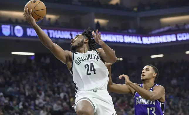 Brooklyn Nets guard Cam Thomas (24) lays up the ball over Sacramento Kings forward Keegan Murray (13) during the first half of an NBA basketball game in Sacramento, Calif., Sunday, Nov. 24, 2024. (AP Photo/Randall Benton)