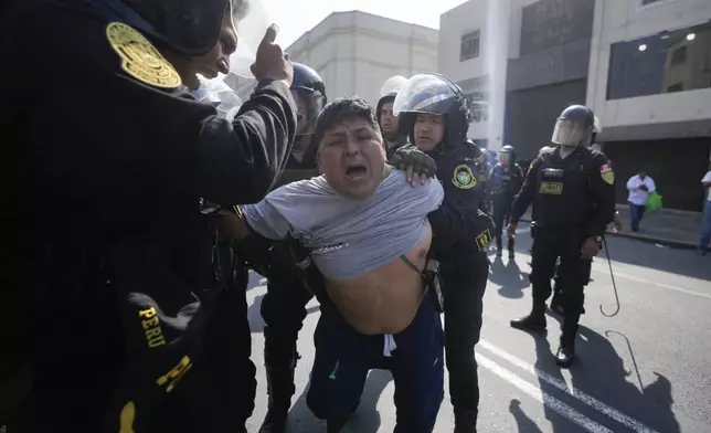 Police detain an anti-government protester on the sidelines of the Asia-Pacific Economic Cooperation (APEC) summit in Lima, Peru, Wednesday, Nov. 13, 2024. (AP Photo/Fernando Vergara)