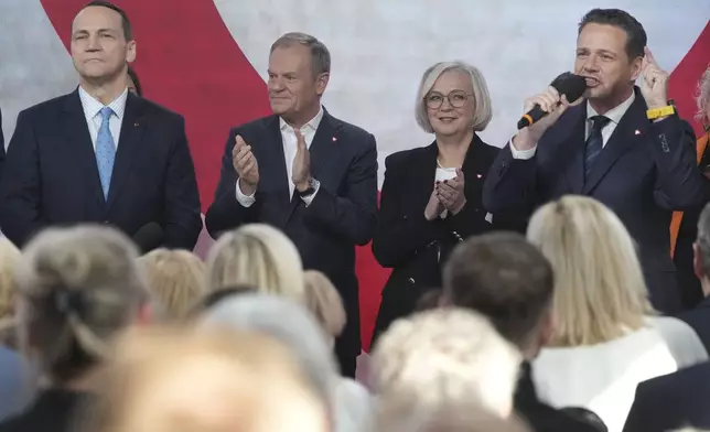 Poland's Foreign Minister Radek Sikorsk, left, and Poland's Prime Minister Donald Tusk, second left, stand on stage with Warsaw Mayor Rafal Trzaskowski, right, for a presidential election announcement in Warsaw, Poland, on Saturday Nov. 23, 2024. (AP Photo/Czarek Sokolowski)