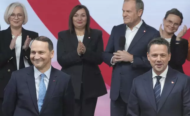 Poland's Foreign Minister Radek Sikorsk, front left, stands on stage with Warsaw Mayor Rafal Trzaskowski, front right, for a presidential election announcement in Warsaw, Poland, on Saturday Nov. 23, 2024. (AP Photo/Czarek Sokolowski)