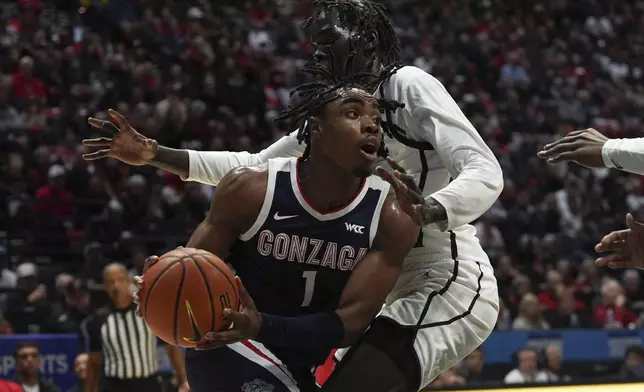 Gonzaga guard Michael Ajayi (1) gets past San Diego State forward Magoon Gwath during the first half of an NCAA college basketball game Monday, Nov. 18, 2024, in San Diego. (AP Photo/Gregory Bull)