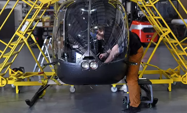 Avionics Technician John Beto installs components into the cockpit of an unmanned semi-autonomous helicopter being built in a hanger at Rotor Technologies , Monday, Nov. 11, 2024, in Nashua, N.H. (AP Photo/Charles Krupa)