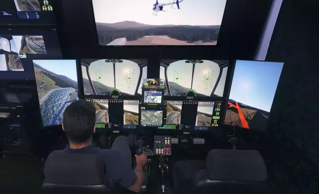 Joao Magioni, Chief Flight Officer of Rotor Technologies, flies a simulated unmanned semi-autonomous helicopter from the company's remote operations center, Monday, Nov. 11, 2024, in Nashua, N.H. The interface can also be used as a ground control station for real-time flight operations. (AP Photo/Charles Krupa)