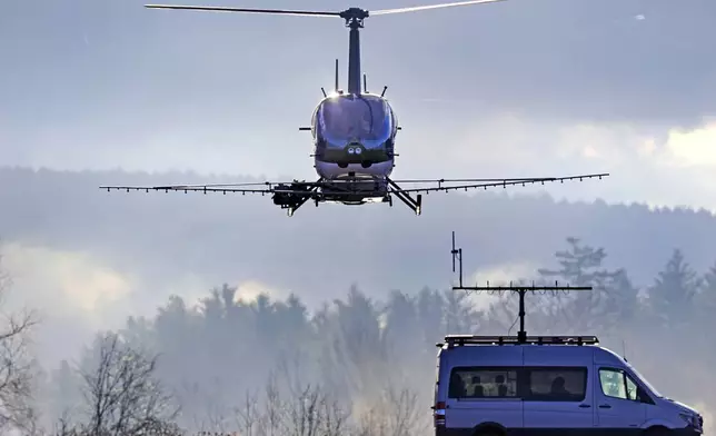 A Rotor Technologies unmanned semi-autonomous helicopter flies away from a van containing a ground control pilot/operator during a test flight over Intervale Airport, Monday, Nov. 11, 2024, in Henniker, N.H. (AP Photo/Charles Krupa)