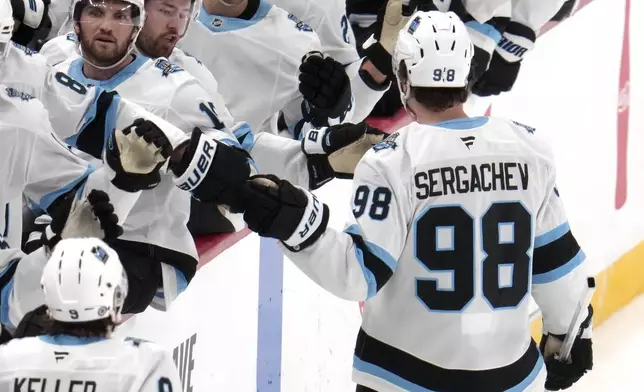 Utah Hockey Club's Mikhail Sergachev (98) returns to the bench after scoring during the first period of an NHL hockey game against the Pittsburgh Penguins, Saturday, Nov. 23, 2024, in Pittsburgh. (AP Photo/Gene J. Puskar)